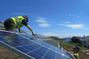 a person installs solar PV panels on the Isle of Canna