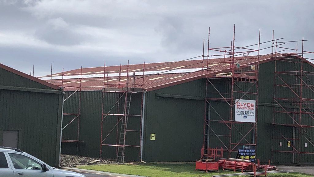 solar panels being installed on the roof of a hangar at Strathaven Airfield